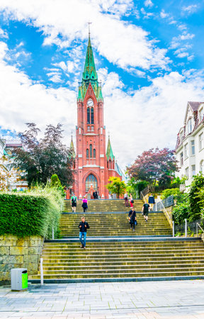 BERGEN, NORWAY, AUGUST 22, 2016: People are passing by red Johanneskirken church in the norwegian city Bergen.のeditorial素材