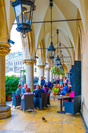 KRAKOW, POLAND, AUGUST 11, 2016: People are having lunch under arches of sukiennice marketplace in the polish city Cracow / Krakow.のeditorial素材