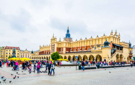 KRAKOW, POLAND, AUGUST 11, 2016: People are strolling in front of the Sukiennice marketplace (Cloth Hall, Drapers' Hall) in Krakow (Cracow), Polandのeditorial素材