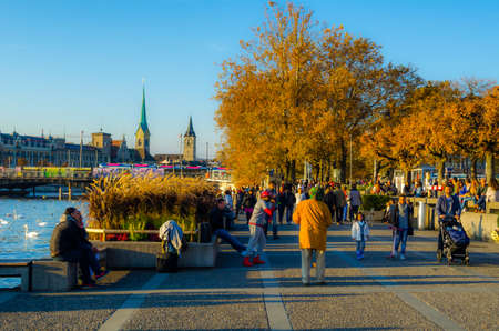 ZURICH, SWITZERLAND, OCTOBER 24, 2015: people are walking on a sunny promenade along the zurich lake in switzerland during late autumn afternoonのeditorial素材