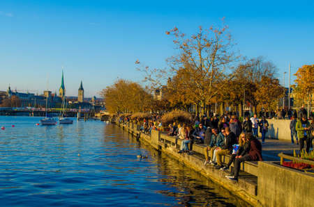 ZURICH, SWITZERLAND, OCTOBER 24, 2015: people are walking on a sunny promenade along the zurich lake in switzerland during late autumn afternoonのeditorial素材