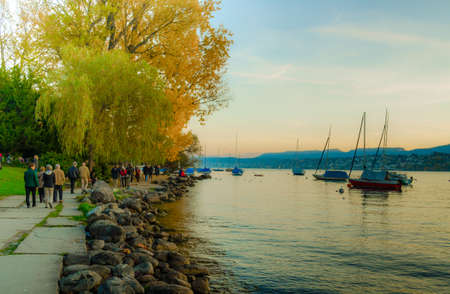 ZURICH, SWITZERLAND, OCTOBER 24, 2015: people are walking on a sunny promenade along the zurich lake in switzerland during late autumn afternoonのeditorial素材