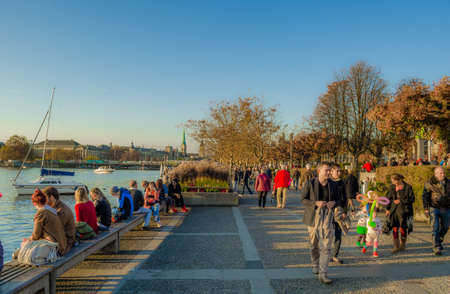 ZURICH, SWITZERLAND, OCTOBER 24, 2015: people are walking on a sunny promenade along the zurich lake in switzerland during late autumn afternoonのeditorial素材