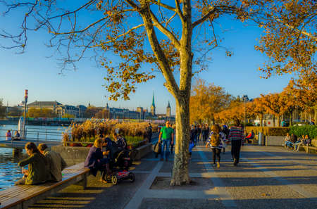 ZURICH, SWITZERLAND, OCTOBER 24, 2015: people are walking on a sunny promenade along the zurich lake in switzerland during late autumn afternoonのeditorial素材