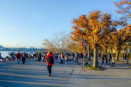 ZURICH, SWITZERLAND, OCTOBER 24, 2015: people are walking on a sunny promenade along the zurich lake in switzerland during late autumn afternoonのeditorial素材