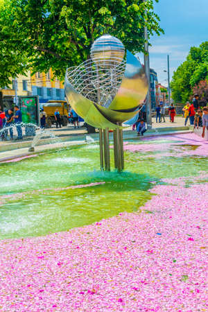 KAZANLAK, BULGARIA, JUNE 4, 2017: People sit next to a fountain covered with rose petals during famous rose festival in Kazanlak, Bulgariaのeditorial素材