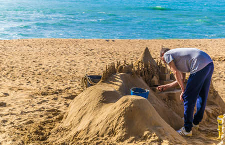 CADIZ, SPAIN, JANUARY 6, 2016: a group of sculptors is preparing a statue of a sand castle on a beach in the spanish city cadiz.のeditorial素材