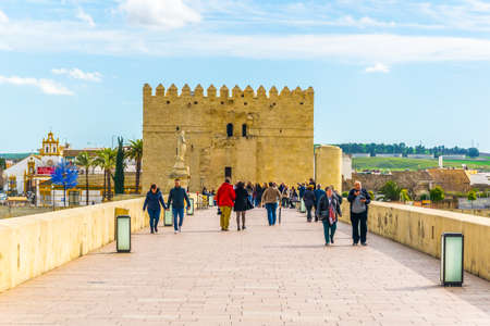 CORDOBA, SPAIN, JANUARY 8, 2016: people are walking over the roman bridge in the spanish city cordoba towards the la mezquita cathedral.のeditorial素材