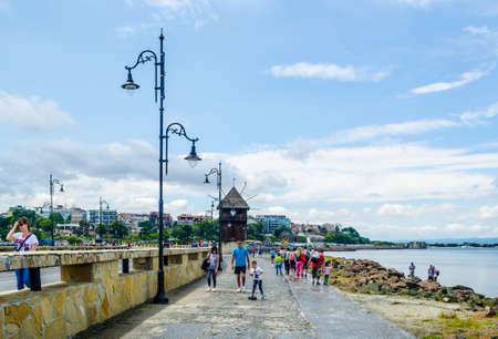 NESSEBAR, BULGARIA, JULY 14, 2015: People are passing an old windmill on the way to the unesco world heritage city nessebar in bulgaria.のeditorial素材