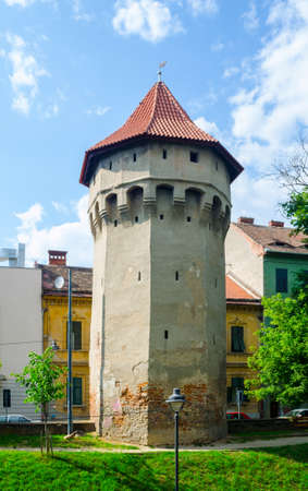 SIBIU, ROMANIA, JULY 6, 2015: Unidentified people wander along the medieval defense wall and The Carpenters' Tower in Sibiu city, Transylvania region, Romania.のeditorial素材