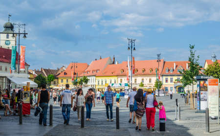 SIBIU, ROMANIA, JULY 6, 2015: people stroll along the boulevard nicolae balcescu or enjoy a sunny day in the Great Square, the largest square in the upper town and an architectural monument by UNESCO.のeditorial素材
