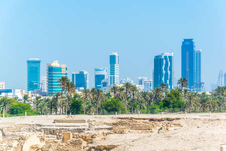 MANAMA, BAHRAIN, OCTOBER 22, 2016: View of the Bahrain fort complex with the Qal'At Al Bahrain fort with modern skyscrapers visible at horizon.のeditorial素材
