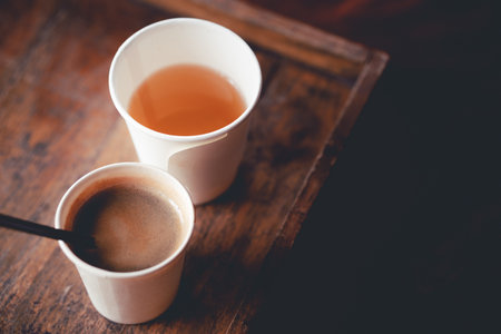 Morning hot coffee, and tea in paper cup, on wooden table, top view, bathed in warm light, close-up,morning comfort, in the midst of natural light,の写真素材