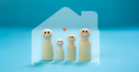 Insurance concept. Wooden dolls. Family, parents and children. Happy smiling face in a warm house bright blue background The concept of family protection Take care of safety.の写真素材