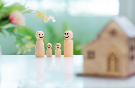 Happy family concept. Wooden figurine of family with house model.の写真素材