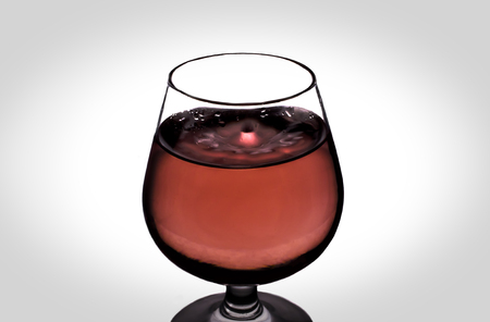 The falling drops of water into the wine glassの写真素材