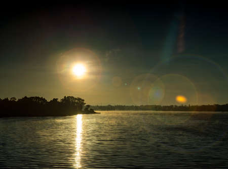 Sunset on the lake. The sun is reflected in the water.の写真素材