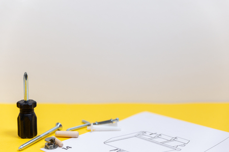 Group of equipment for furniture assembly on yellow board with space for text.の写真素材