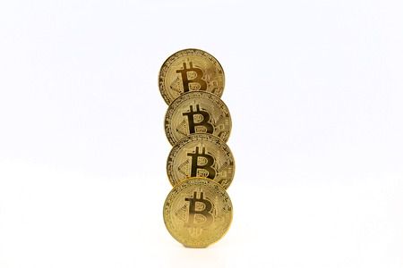 Four Bitcoin tokens stacked isolated on white background. Cryptocurrency concept with copy space.の写真素材
