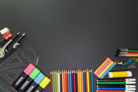 School supplies on black board background. Education, back to school concept with copy space
