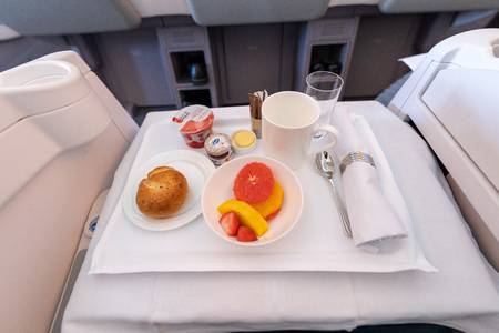 DUBAI, UAE - CIRCA 2019: Emirates airline business class interior with food tray. Emirates is the flag carriers of the United Arab Emirates.のeditorial素材