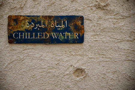 Old chilled water sign with rust on it. Arabic writing can read Chilled Water on a rusting blue sign...