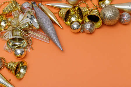 Christmas composition. Gifts, tree branches, golden and silver decorations on orange background. Christmas, winter, new year concept. Flat lay, top view, copy space.の写真素材