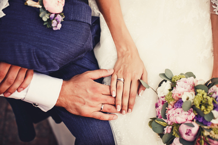 Close up of holding hands with wedding ringsの写真素材
