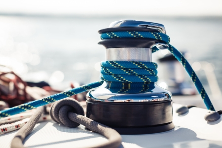 Closeup on yacht cord crank, rope holder on white sail の写真素材