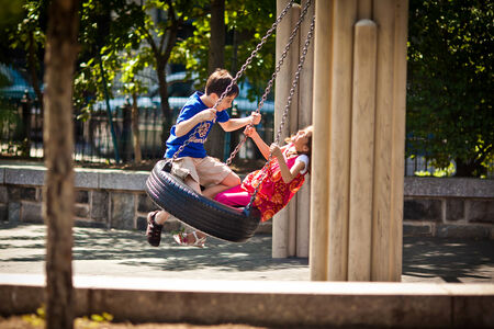 BROOKLYN, NEW YORK - JULY 7, 2011: Two children having fun on a swing in playground of New York on July 7, 2011, Brooklyn, USAのeditorial素材