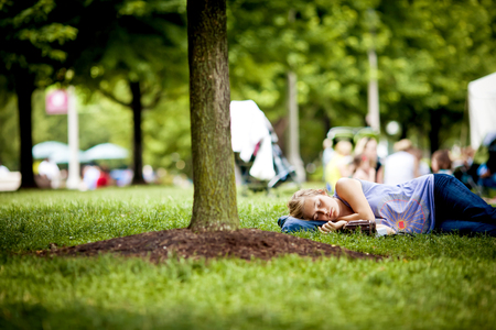 CHICAGO, USA - JULY 7, 2011: Girl sleeping under tree in park on July 7, 2011, Chicago, USAのeditorial素材