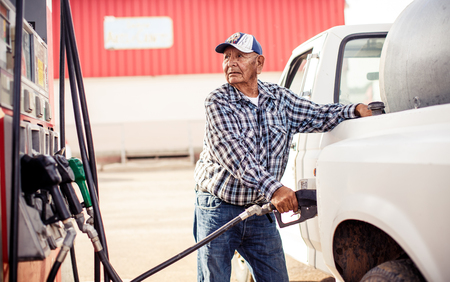 ARIZONA, USA - AUGUST 02, 2013: Native American old man in Monument valley filling up a car on August 02, 2013, Arizona, USAのeditorial素材