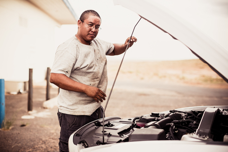 ARIZONA, USA - AUGUST 03, 2013: Native American man repairing car on August 02, 2013, Arizona, USAのeditorial素材