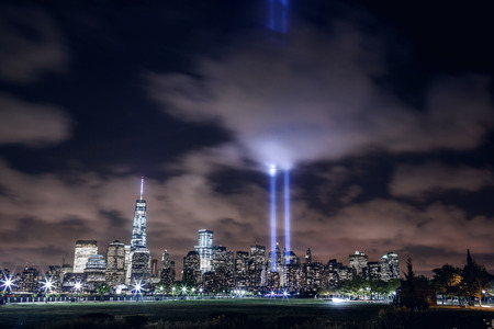 NEW YORK, UNITED STATES - SEPTEMBER 11: illuminated Manhattan skyline with two beams of light in...