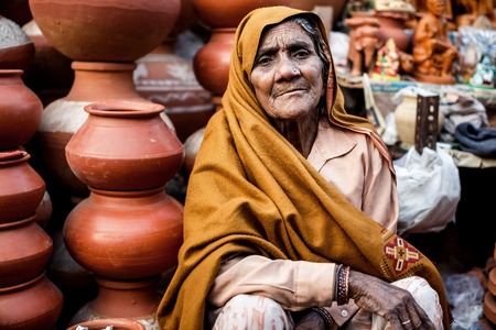 DELHI, INDIA - JANUARY 4, 2015: Indian woman selling clay pots on local market  on January 4, 2015 in Delhi, Indiaのeditorial素材