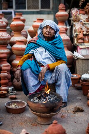 DELHI, INDIA - JANUARY 4, 2015: Indian woman selling clay pots on local market  on January 4, 2015 in Delhi, Indiaのeditorial素材