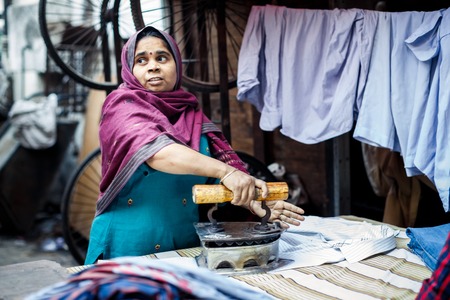 DELHI, INDIA - JANUARY 4, 2015: Mature Indian woman ironing clothes on January 4, 2015 in Delhi, Indiaのeditorial素材