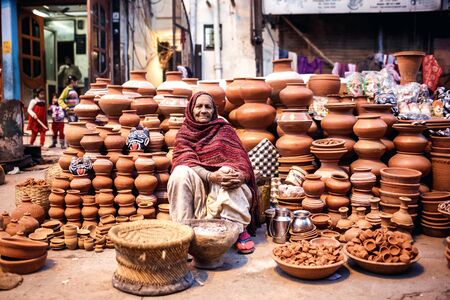 DELHI, INDIA - JANUARY 4, 2015: Indian woman selling clay pots on local market  on January 4, 2015 in Delhi, Indiaのeditorial素材