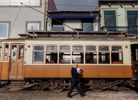 PORTO, PORTUGAL - OCTOBER 19, 2015: Driver of Famous old tram on street of Porto. Trams operating in Porto since 1872のeditorial素材