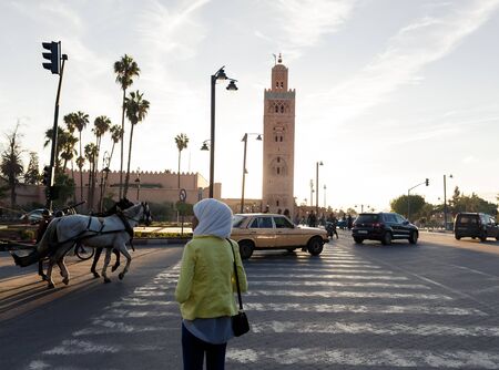 MARRAKECH, MOROCCO - OCTOBER 27, 2015:  Woman crossing street at Marrakech medina near the UNESCO...