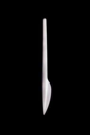 Plastic knife on a black background isolateの写真素材