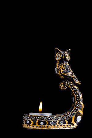 Candlestick owl with candles on a black background isolateの写真素材