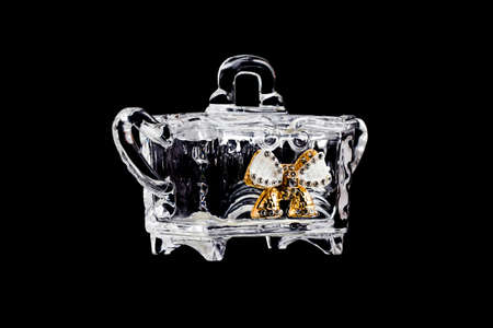 jewelry glass box with a gold bow on a black background isolateの写真素材