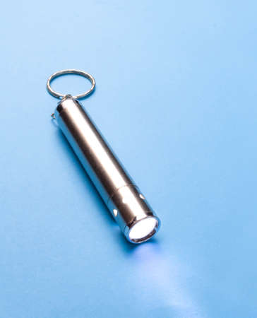 Small flashlight on a blue background