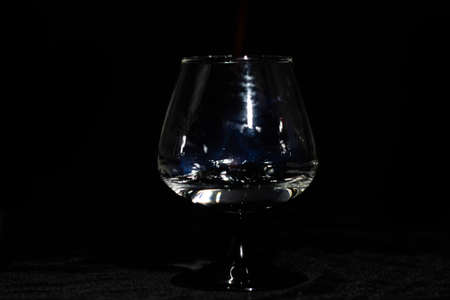 Cognac glass with a burning sambuca on a black background aloneの写真素材