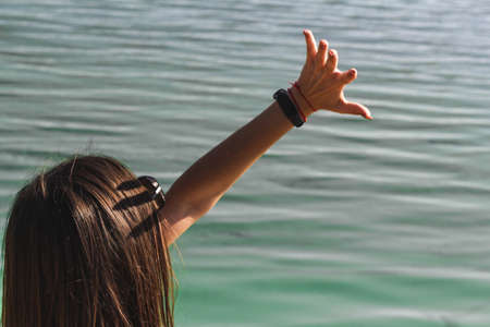 The girl closes his hand from the sun on the background of the river oneの写真素材