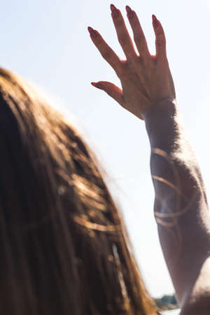Girl closes her hand from the sun oneの写真素材