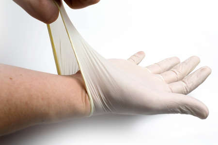 Silicone medical glove put on a hand on a white backgroundの写真素材