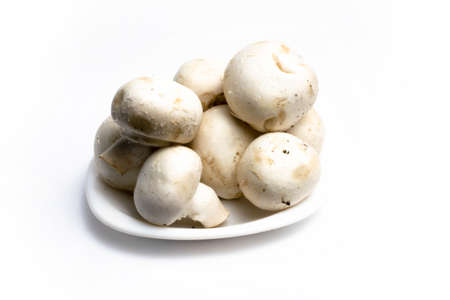 Champignon mushrooms in a plate on a white background isolateの写真素材