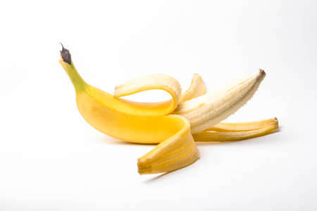 ripe yellow banana half peeled on a white background isolateの写真素材